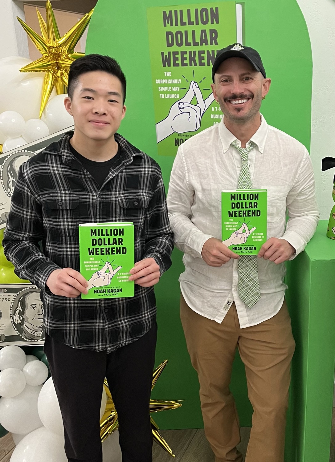Jay Yang and Noah Kagan holding copies of Million Dollar Weekend at the book launch.